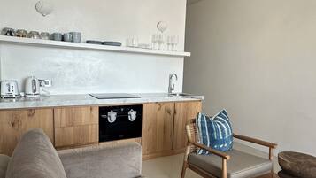 A modern kitchen with a built-in oven, a wooden cabinet, and a white countertop.