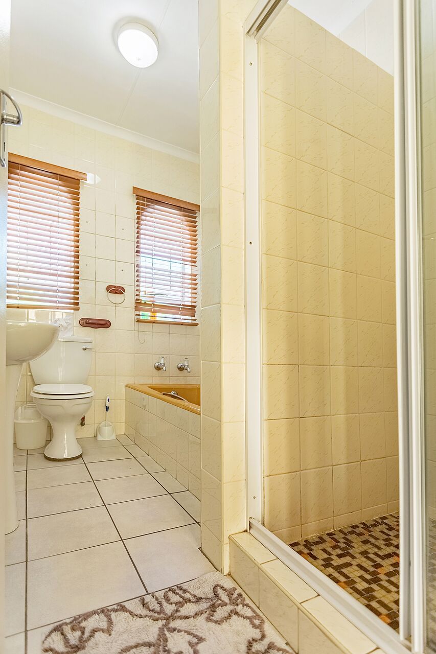 Ein Badezimmer mit Toilette, Waschbecken, Badewanne und Duschbereich.