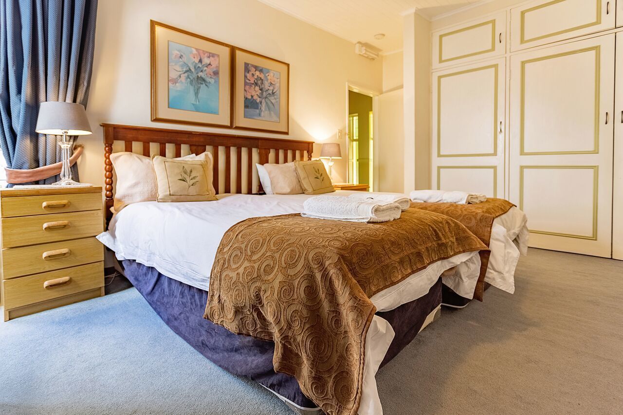 Un dormitorio con una cama grande, una mesita de noche de madera, un aparador y un armario.