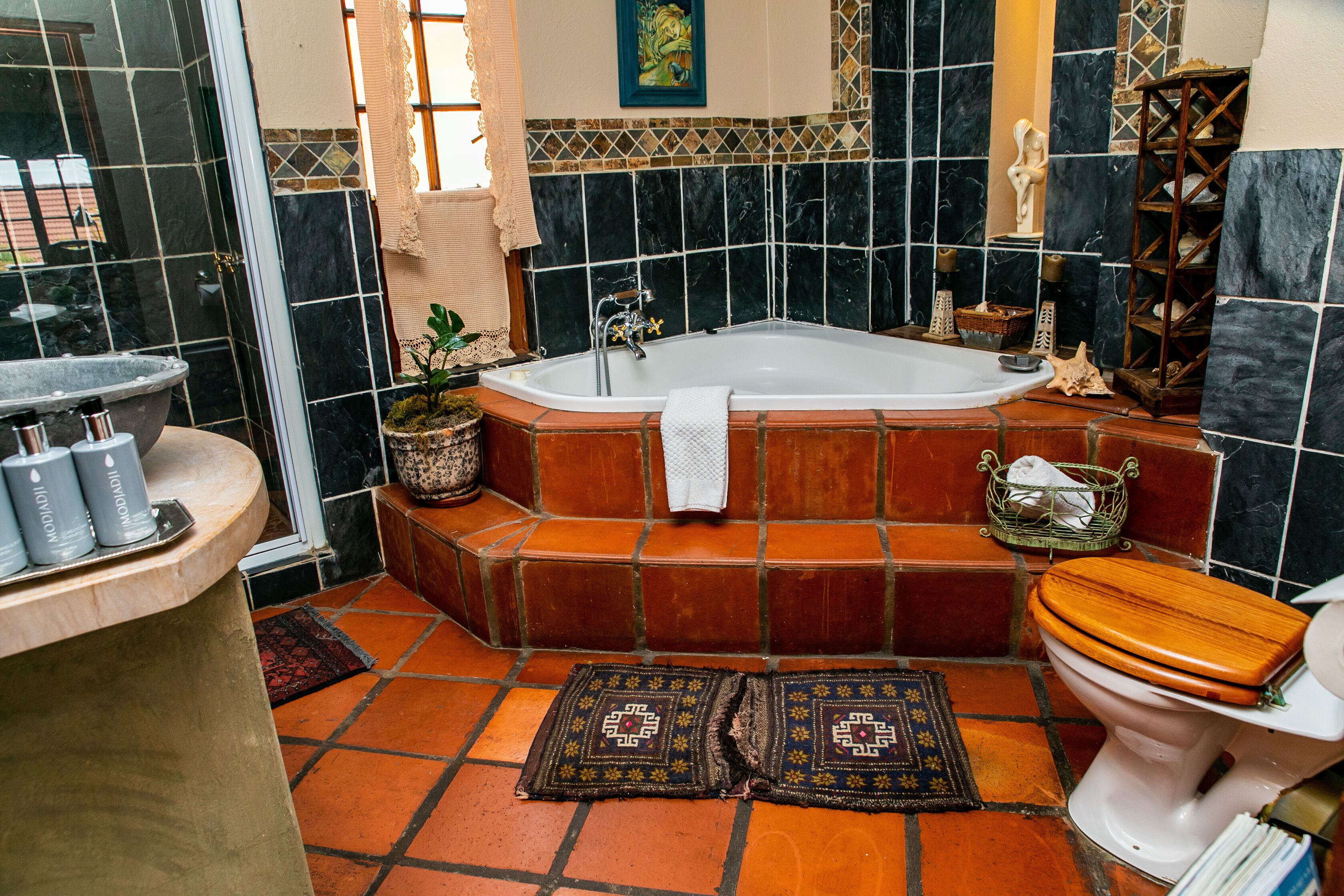 Een badkamer met een bad, toilet en wastafel.