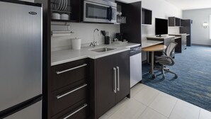 Una cocina moderna con refrigerador, microondas, pileta y armarios.