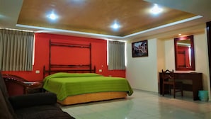 Un dormitorio con cama, escritorio y silla.