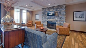 A modern living room with a stone fireplace, comfortable seating, and a large vase.