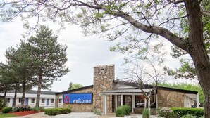 A hotel with a stone facade, a '6 welcome' sign, and a parking lot. - Motel 6 Erie, PA (Erie)