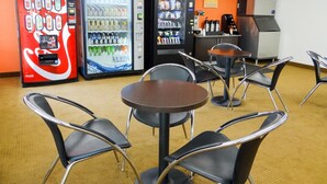 A room with vending machines, including Coca-Cola and Aquafina, and a coffee machine. There are tables and chairs for seating. - Motel 6 Erie, PA (Erie)