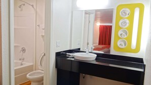 A bathroom with a white sink, black countertop, and a mirror. - Motel 6 Erie, PA (Erie)