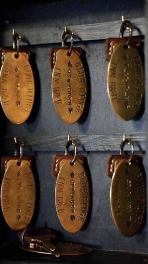 Six keychains with engraved text, each hanging from a leather strap.