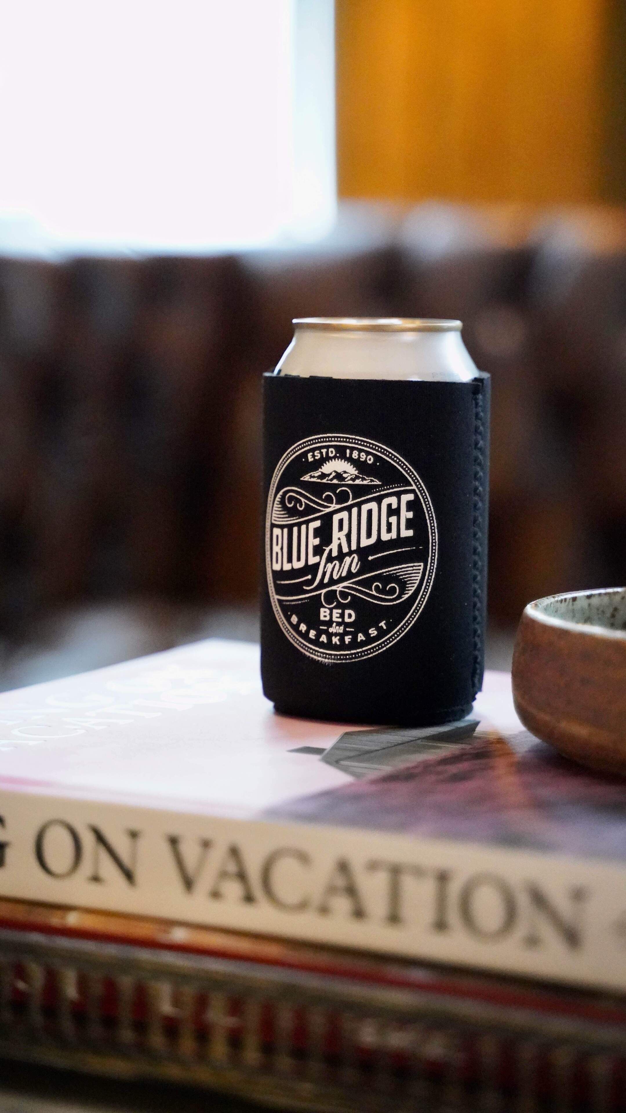 A can of Blue Ridge Inn beer on a table with a book titled "On Vacation".