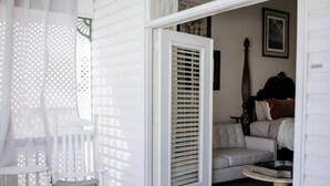 A room with a white door, a grey sofa, a rocking chair, and a small round table. - Blue Ridge Inn Bed & Breakfast (Blue Ridge)