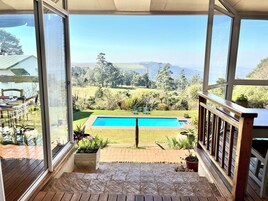 Una piscina al aire libre, sillones reclinables de piscina