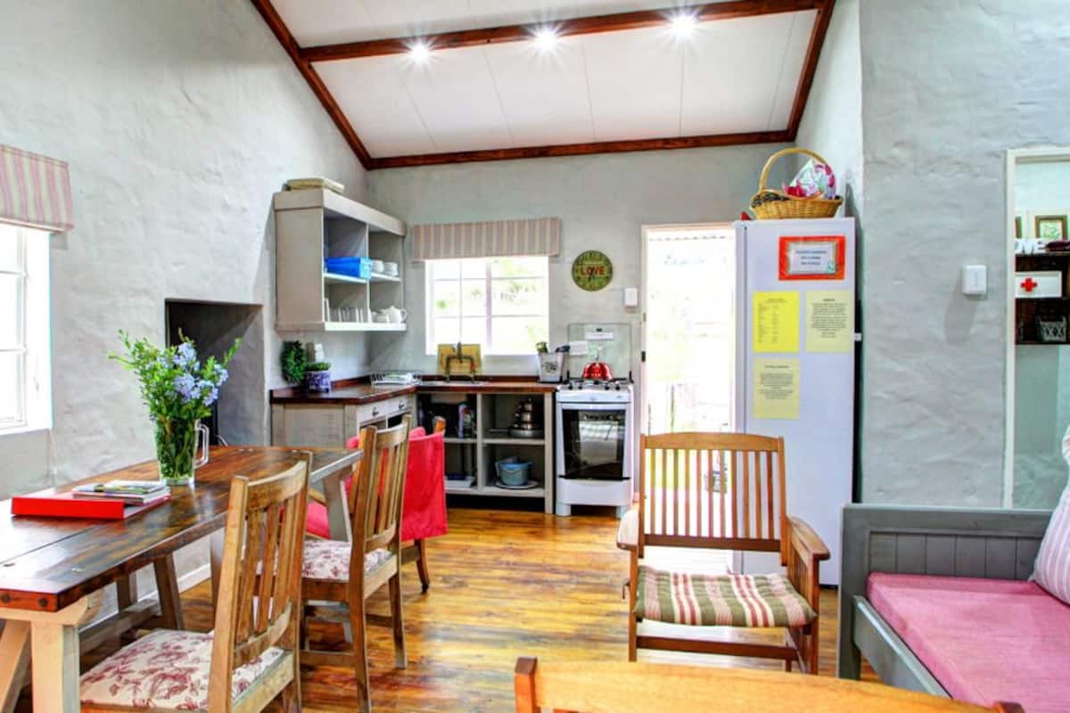 A cozy kitchen with wooden cabinets, a dining table, and a sofa.