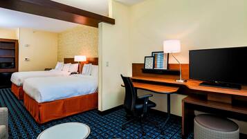 Une chambre d’hôtel avec deux lits, un bureau, une télévision et un four à micro-ondes.