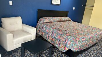 A room with a bed, a chair, and a small table.