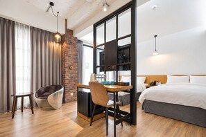 A hotel room with a bed, desk, chair, and a view of the outdoors. - BlueSky Hotel (Taichung)