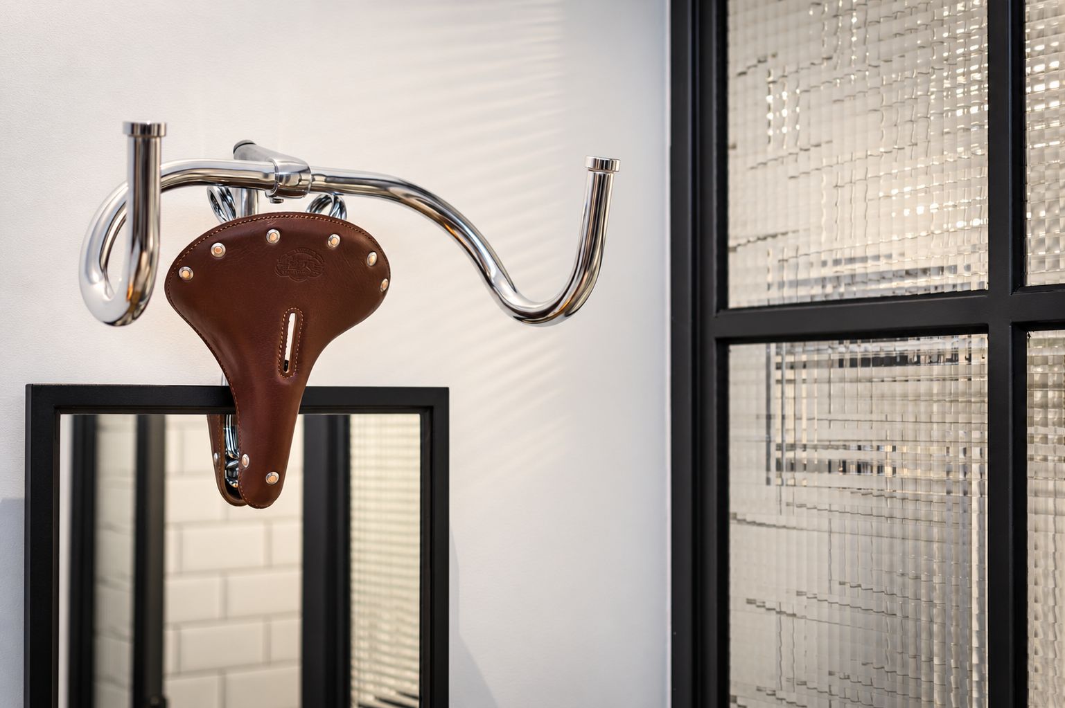 A bathroom with a chrome faucet and a mirror.