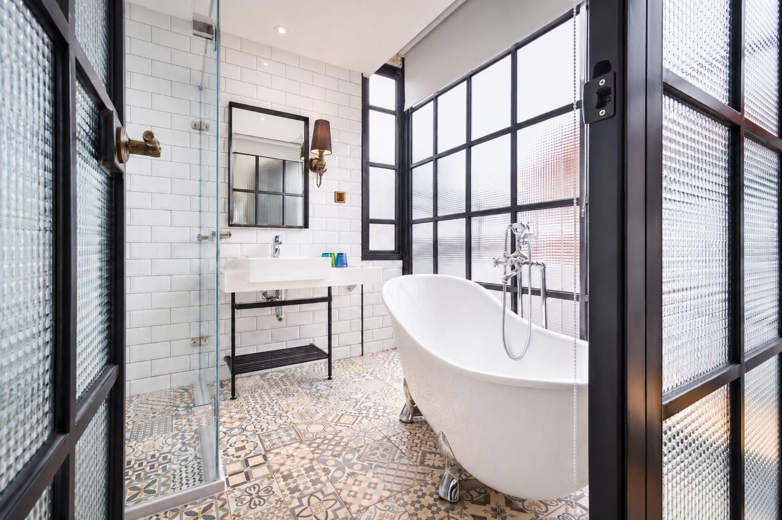 A bathroom with a freestanding bathtub, a sink, and a mirror.