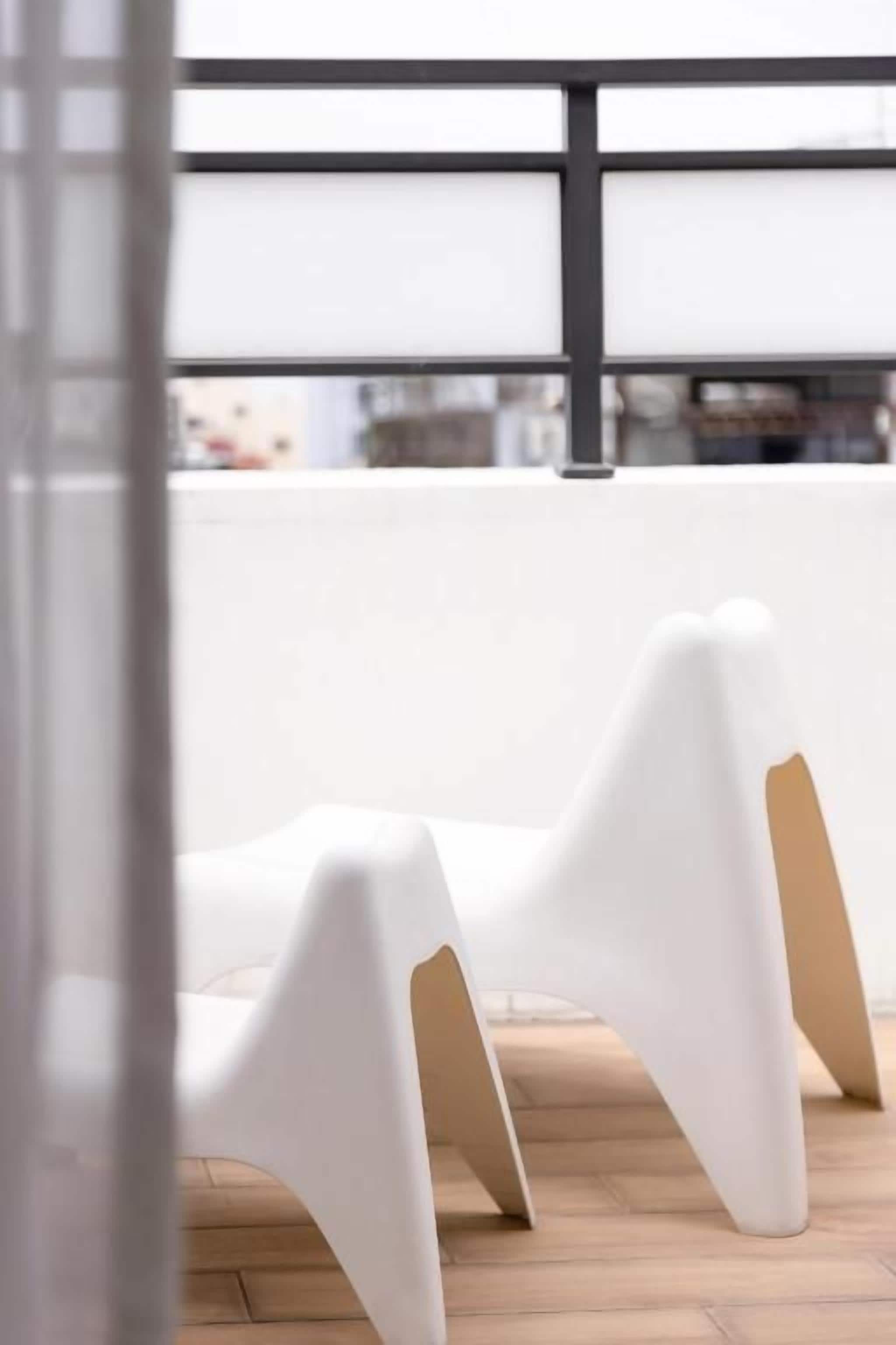 Een modern interieur met witte stoelen en een houten vloer.