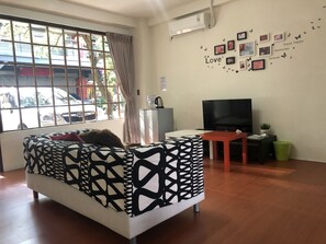 Chambre Premier, Plusieurs lits, patio, rez-de-chaussée | Aire de séjour | Téléviseur