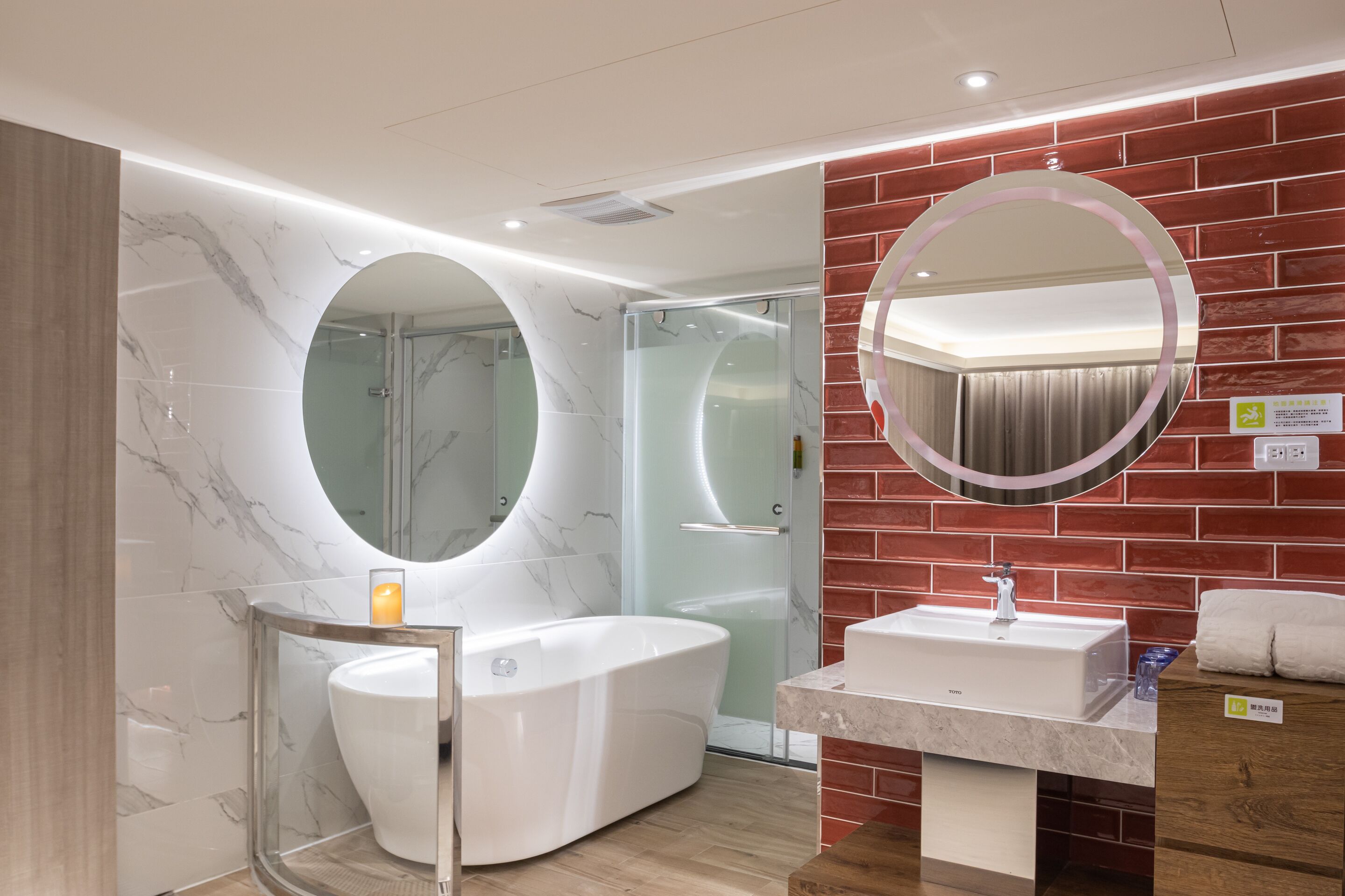 Ein modernes Badezimmer mit Marmor-Waschtisch, freistehender Badewanne und einer Duschkabine aus Glas.