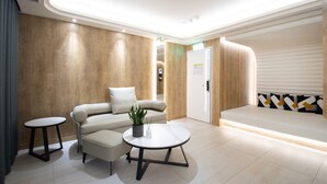 A modern waiting area with a sofa, a small table, and a bench. - 168 Motel - Zhongli (Taoyuan City)