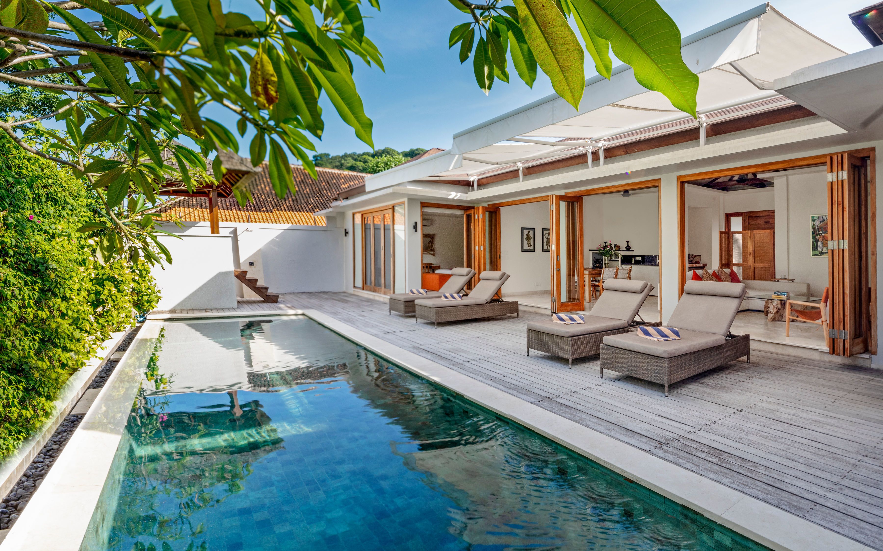 A modern poolside area with lounge chairs and a clear pool.