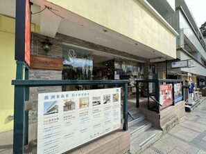 A hotel entrance with a reception desk, a signboard for B&B Groups, and a staircase leading to the entrance. - B&B Cheung Chau (Cheung Chau)