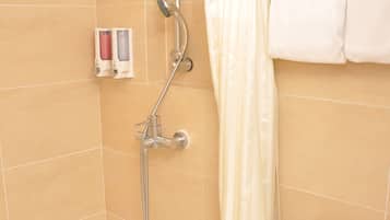 A bathroom with a shower, toilet, and a towel rack.