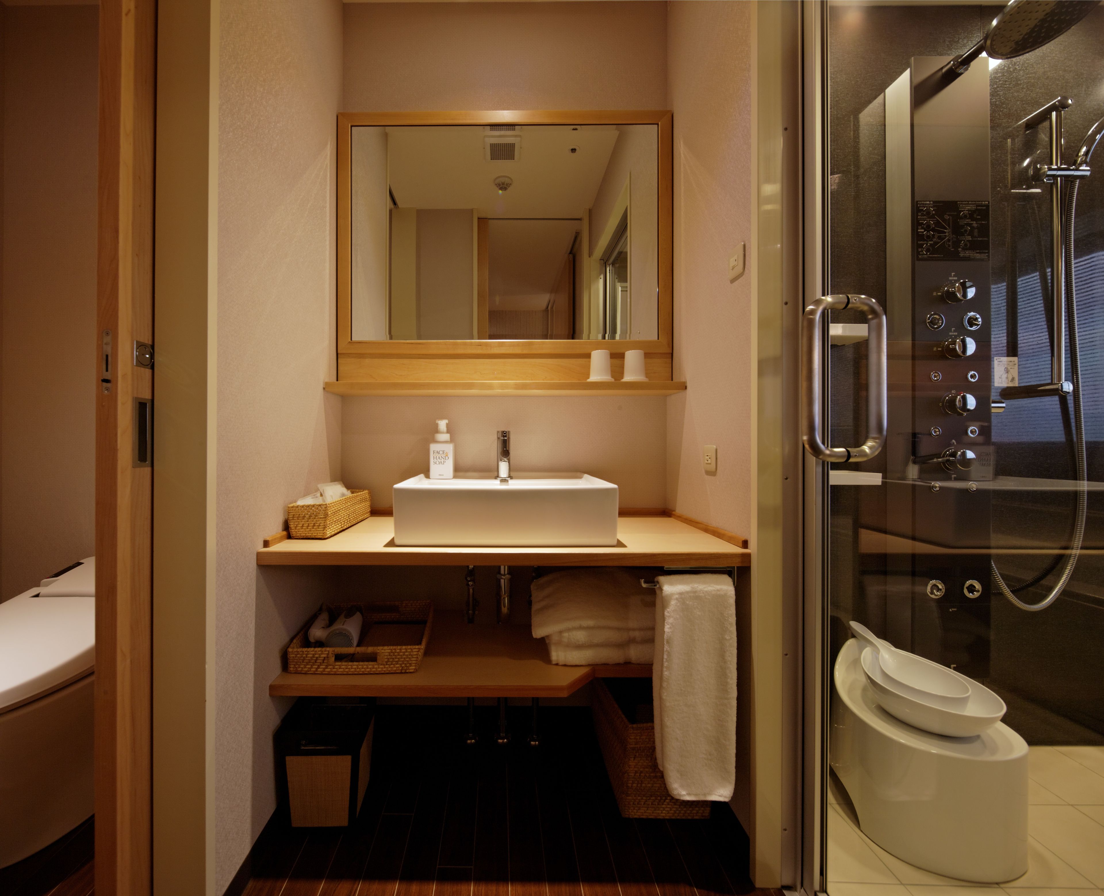 Un baño moderno con lavabo, espejo y ducha.