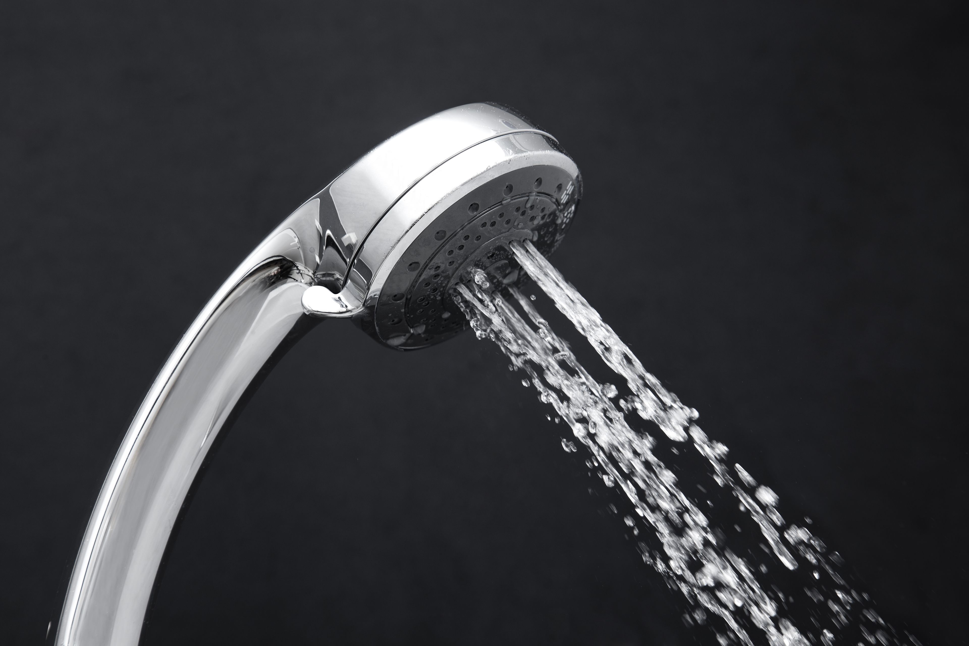 A modern showerhead with water flowing from it.
