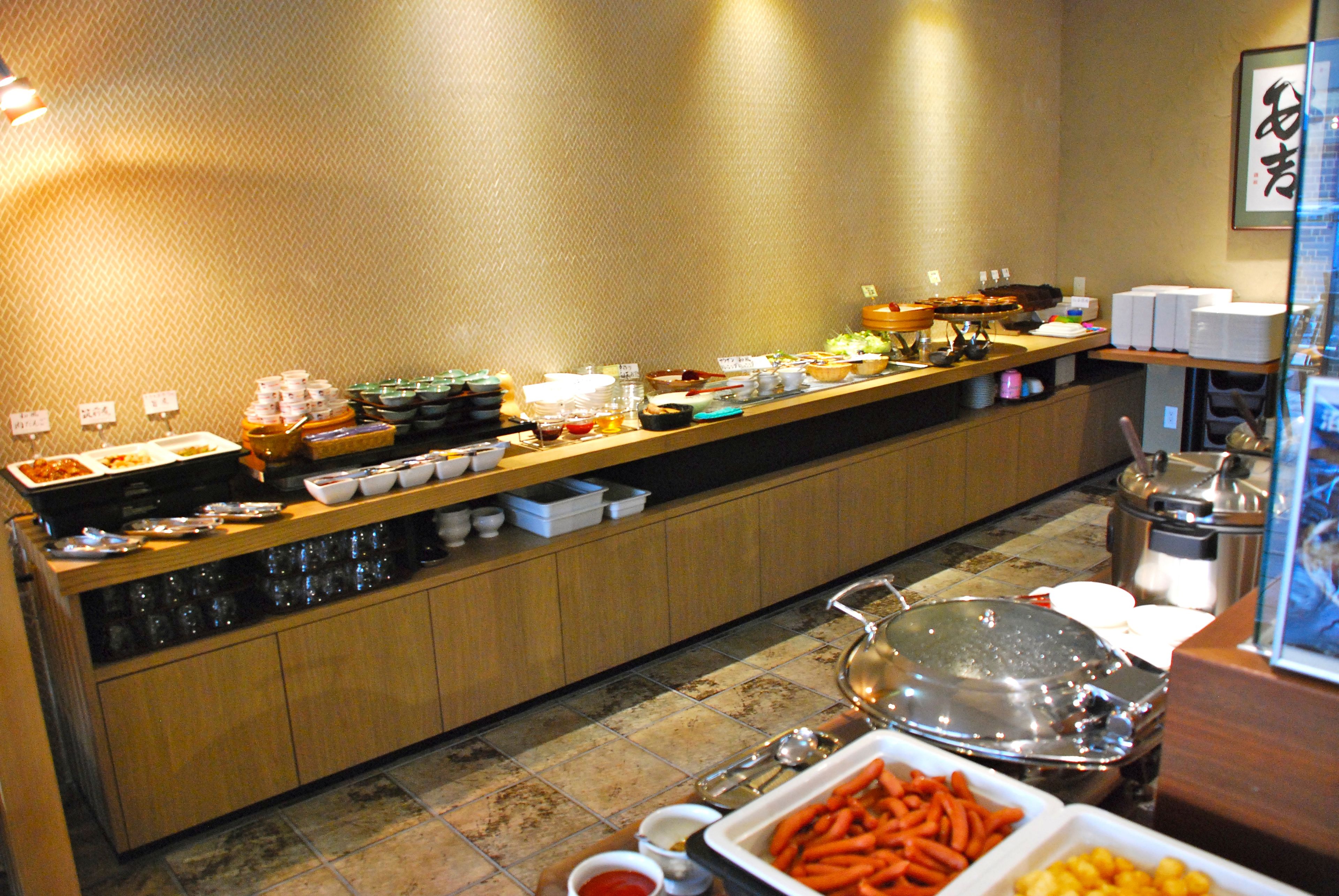 Una mesa de buffet con diversos alimentos y utensilios para servir.