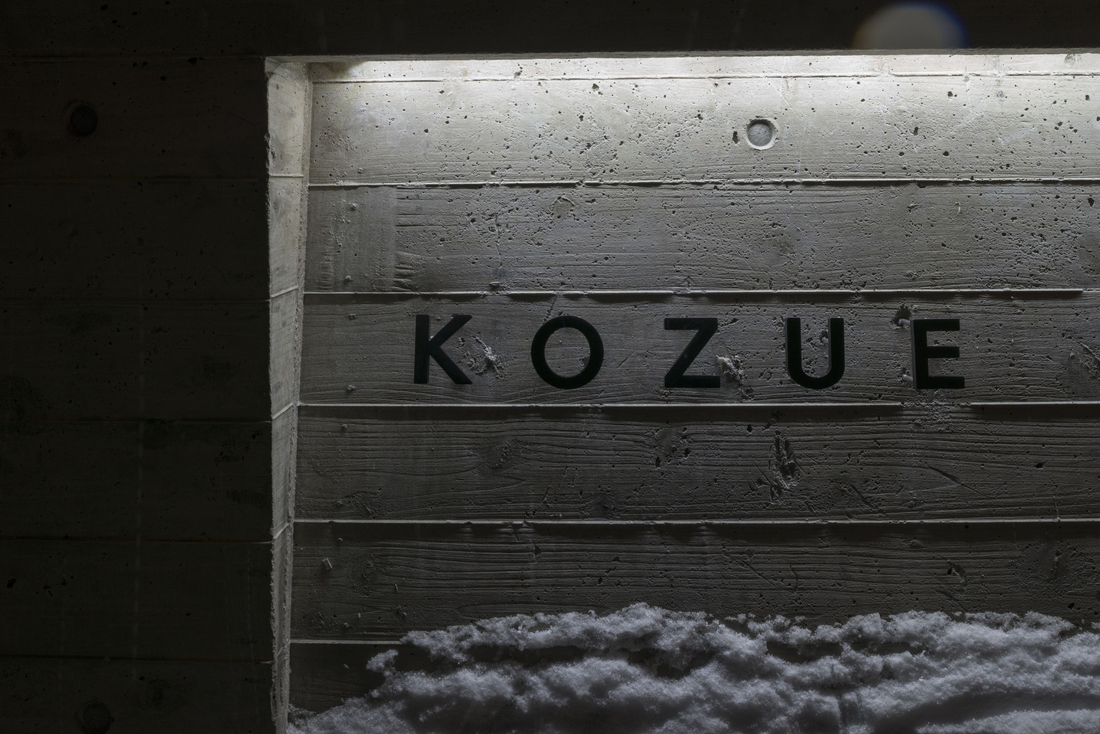 A wooden sign with the word "KOZUE" carved into it.