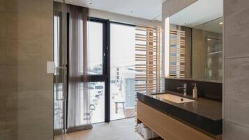Un bagno moderno con uno specchio grande, un lavandino e una zona doccia.