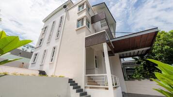 Stunning two-story residence with a flat roof and balcony, featuring a clean exterior and windows on both floors.