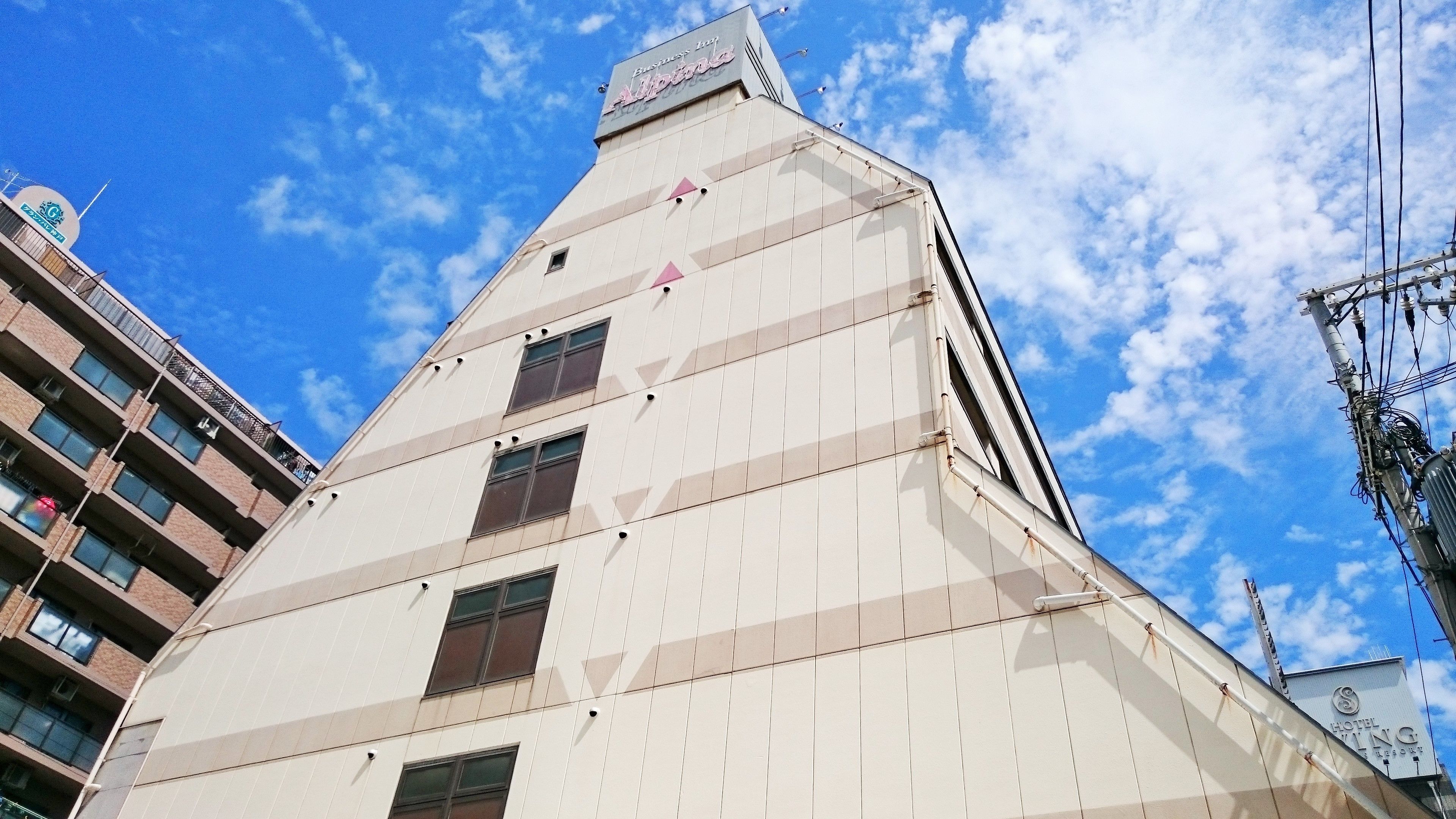 A modern building with a triangular roof and multiple windows.