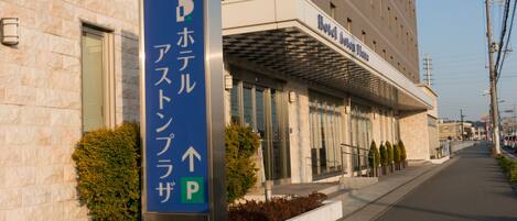 A hotel entrance with a sign indicating a parking area.