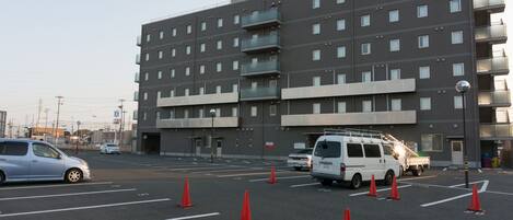A multi-story building with a modern architectural design, featuring balconies and a flat roof.
