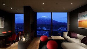 A modern living room with a large window overlooking a snowy mountain. - Terrazze Niseko (Kutchan)