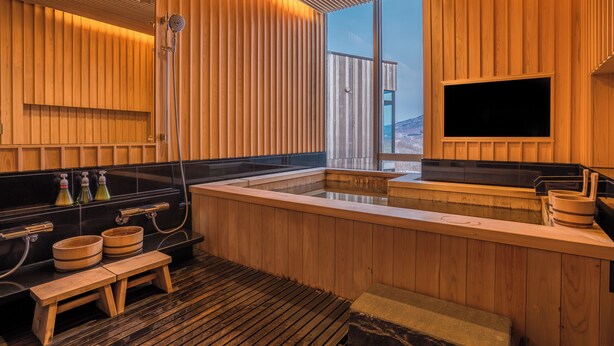 A modern sauna with wooden panels, a large window, and a television. - Terrazze Niseko (Kutchan)