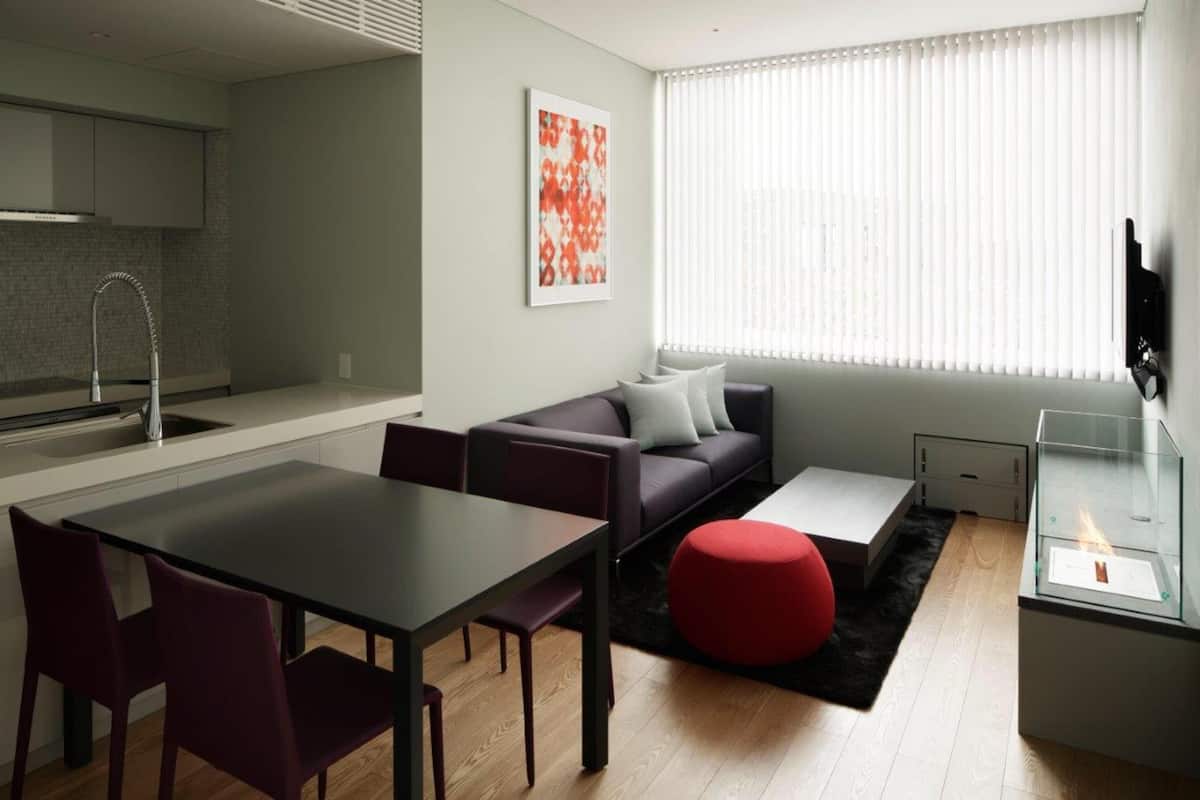 A modern living space with a kitchen, dining area, and seating area.