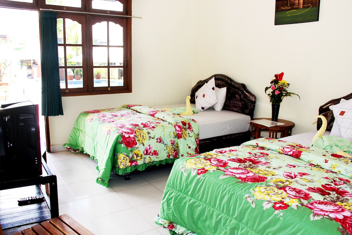 A room with two beds, a TV, and a small table.