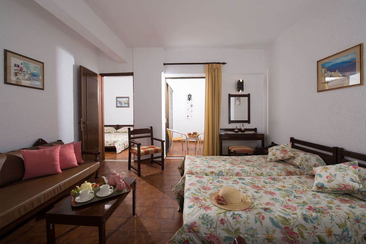 Ein Hotelzimmer mit Bett, Sofa, Esstisch und einer kleinen Küchenzeile.