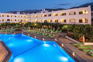 Ein Hotel mit Schwimmbad, mehreren Balkonen und einer angelegten Gartenanlage.