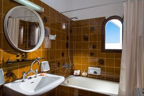 Ein Badezimmer mit Waschbecken, Spiegel, Dusche und Badewanne.