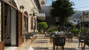 An outdoor patio with wicker furniture and a stone building in the background.