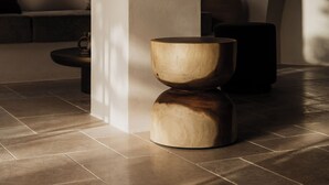 A modern interior with a curved wall, a wooden bowl-shaped table, and a round light fixture. - Momi Slow Living Hotel (Hersonissos)