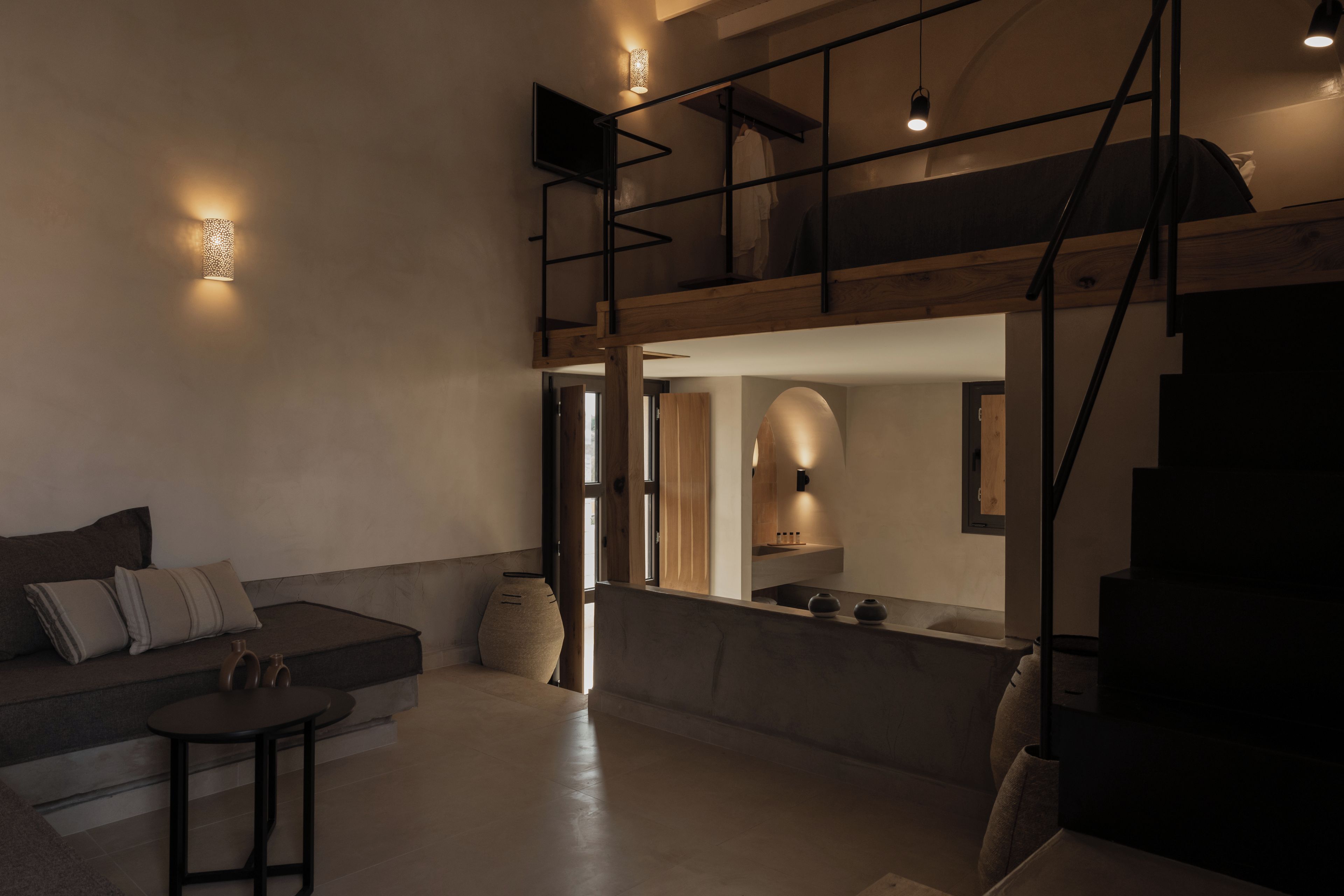 A modern interior with a sofa, a small table, and a staircase.