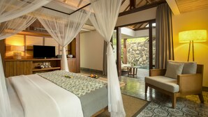 A bedroom with a bed, a television, a bedside table, and a chair. - Jeeva Santai Villas (Senggigi)