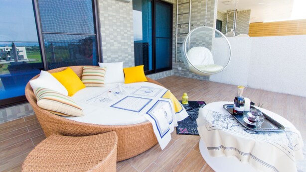 A modern room with a large bed, a hanging chair, and a dining table with a tray. - F One B&B (Wujie)
