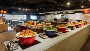 Een buffetopstelling met diverse gerechten en bestek.