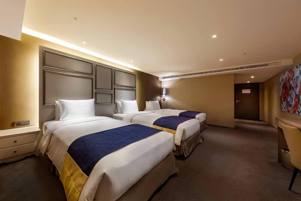 Una habitación de hotel con dos camas, un escritorio y una silla.